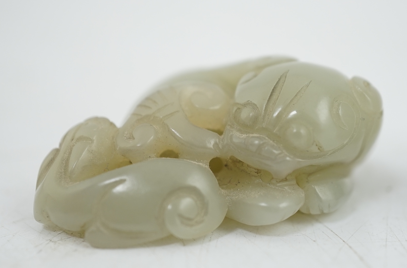 A Chinese white jade lion-dog seal and a Chinese pale celadon jade group of a lion dog and cub, 19th century